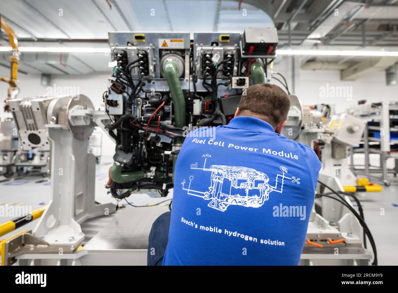 Stoccarda, Germania. 12 luglio 2023. Un dipendente della Robert Bosch GmbH assembla un sistema di azionamento delle celle a combustibile per la generazione di elettricità dall'idrogeno nei veicoli durante la produzione. Il cosiddetto modulo di alimentazione delle celle a combustibile (FCPM) viene utilizzato principalmente nei veicoli commerciali e nelle applicazioni a lunga distanza. L'FCPM è costituito da una o due pile di celle a combustibile e da altri componenti necessari per azionare le pile. Crediti: Marijan Murat/dpa/Alamy Live News Foto Stock