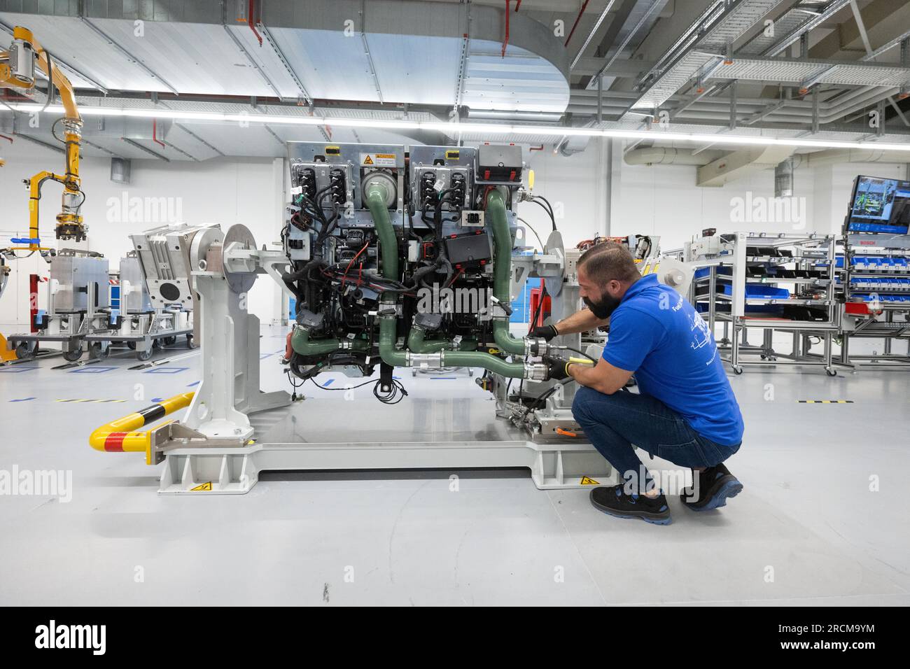 Stoccarda, Germania. 12 luglio 2023. Un dipendente della Robert Bosch GmbH assembla un sistema di azionamento delle celle a combustibile per la generazione di elettricità dall'idrogeno nei veicoli durante la produzione. Il cosiddetto modulo di alimentazione delle celle a combustibile (FCPM) viene utilizzato principalmente nei veicoli commerciali e nelle applicazioni a lunga distanza. L'FCPM è costituito da una o due pile di celle a combustibile e da altri componenti necessari per azionare le pile. Crediti: Marijan Murat/dpa/Alamy Live News Foto Stock