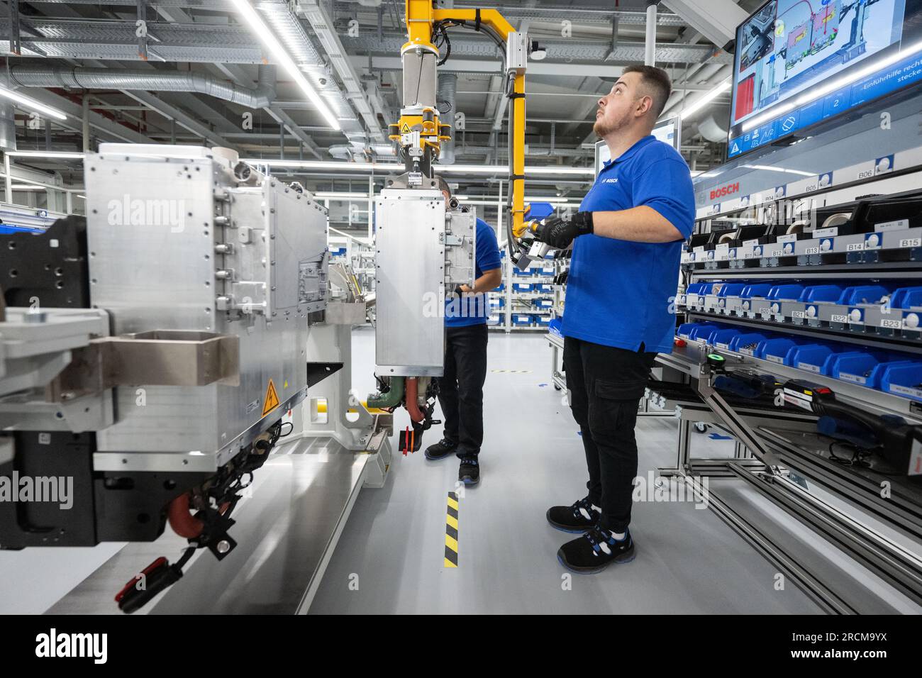 Stoccarda, Germania. 12 luglio 2023. Un dipendente della Robert Bosch GmbH collega una pila di celle a combustibile a un sistema di azionamento delle celle a combustibile per generare elettricità dall'idrogeno nei veicoli durante la produzione. Il cosiddetto modulo di alimentazione delle celle a combustibile (FCPM) viene utilizzato principalmente nei veicoli commerciali e nelle applicazioni a lunga distanza. L'FCPM è costituito da una o due pile di celle a combustibile e da altri componenti necessari per azionare le pile. Crediti: Marijan Murat/dpa/Alamy Live News Foto Stock
