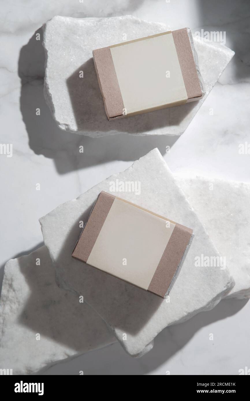 Sapone da bar naturale per pelle e capelli sani in confezione di carta riciclata con etichetta vuota, sudio shot su sfondo martellato. Branding e pubblicità di Foto Stock
