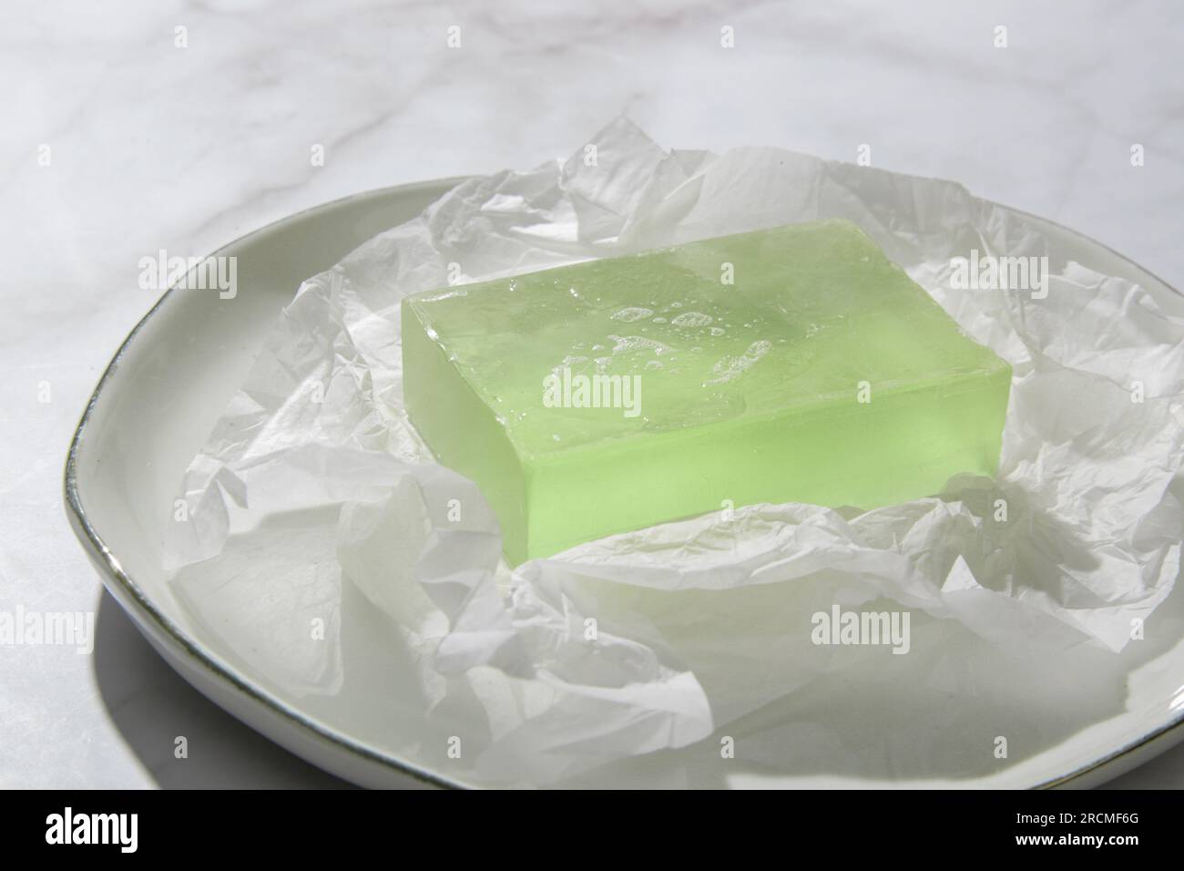Sapone da bar naturale per pelle e capelli sani. Barra di pulizia idratante su carta da imballaggio sfregata Foto Stock