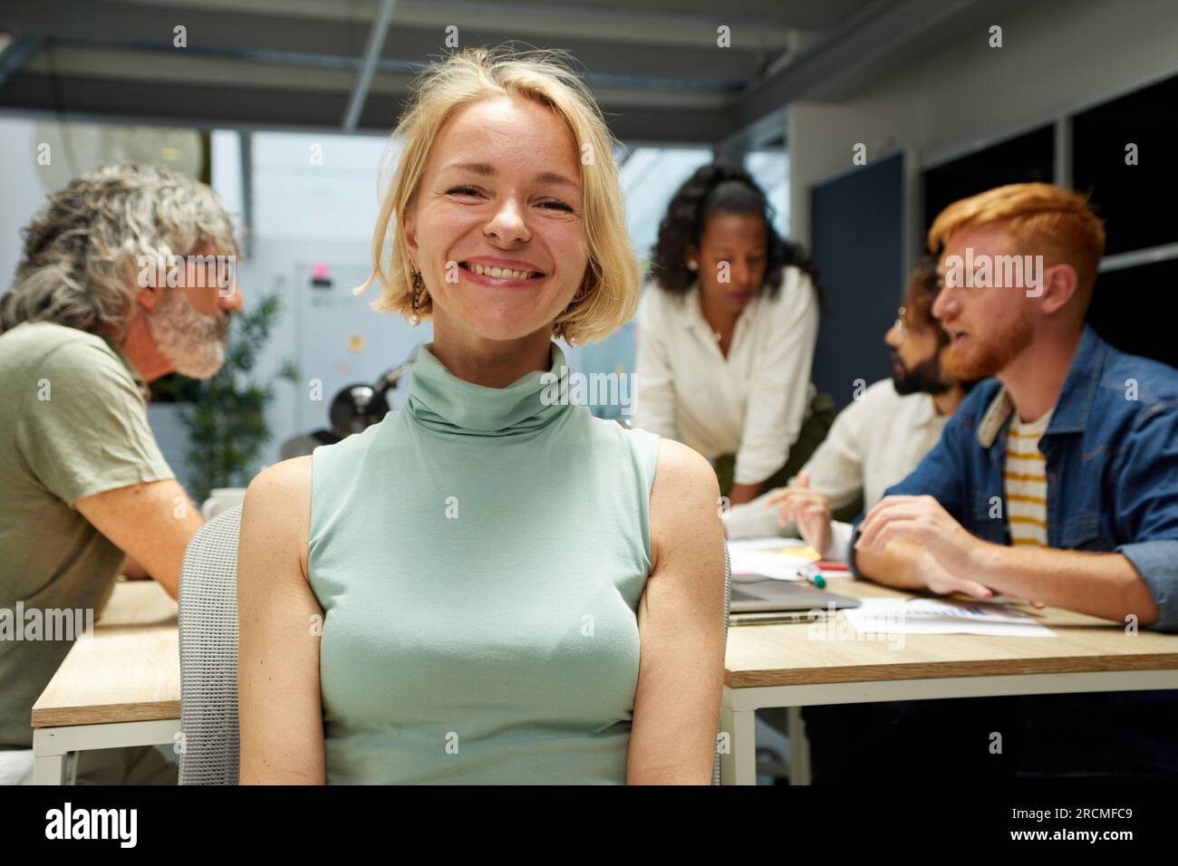 Ritratto di un'allegra donna nordica matura in ufficio e che guarda la fotocamera. Leader femminile potenziato Foto Stock