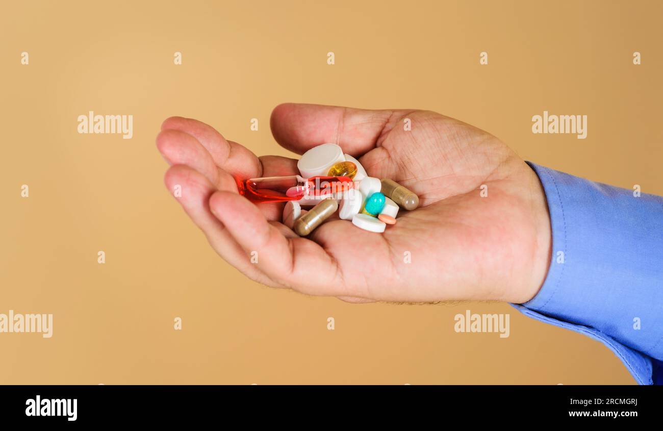 Mano dell'uomo con pillole, capsule e fiala diverse. Vitamine e supplementi del sistema immunitario. Uomo con pillole in mano. Cure e assistenza sanitaria. Manciata Foto Stock