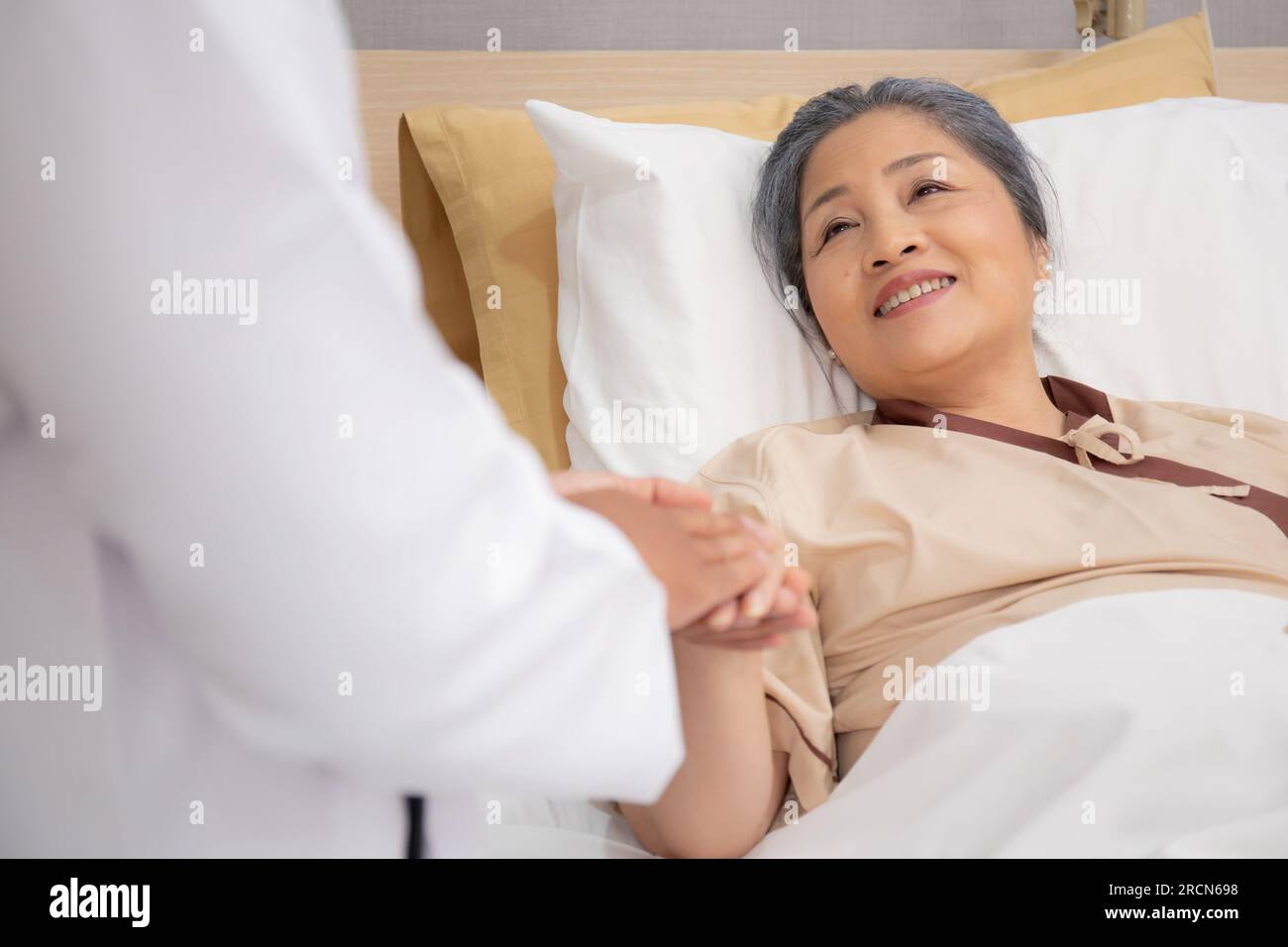 Closeup mani di medico uomo incoraggiare con paziente anziano presso l'ospedale, medico prendersi cura e tenersi per mano per consolare anziani malati, diagnosti Foto Stock