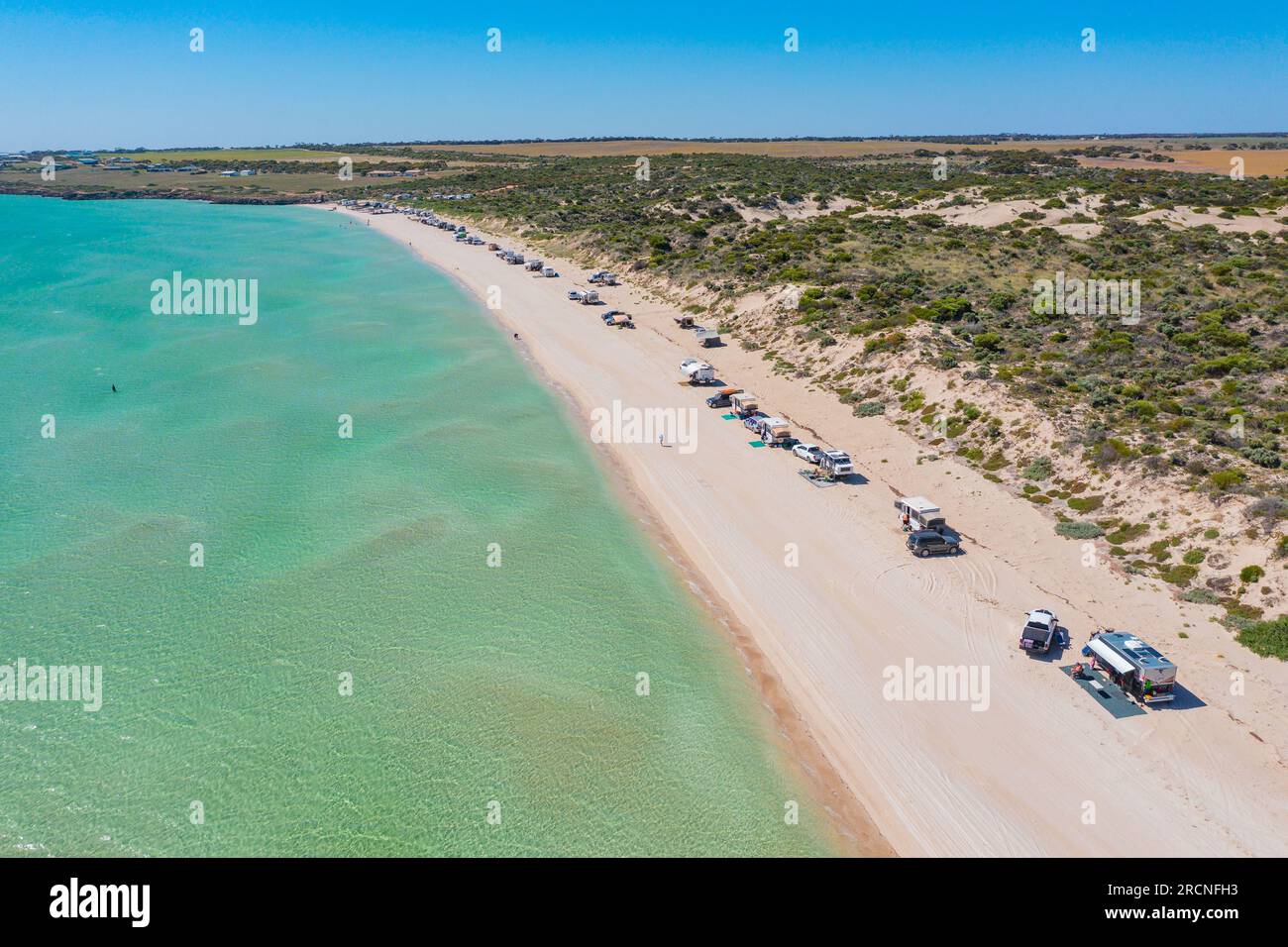 Vista aerea di una fila di roulotte e campeggi su una spiaggia sabbiosa con acque turchesi a Perlubie Beach sulla penisola di Eyre nel sud Foto Stock