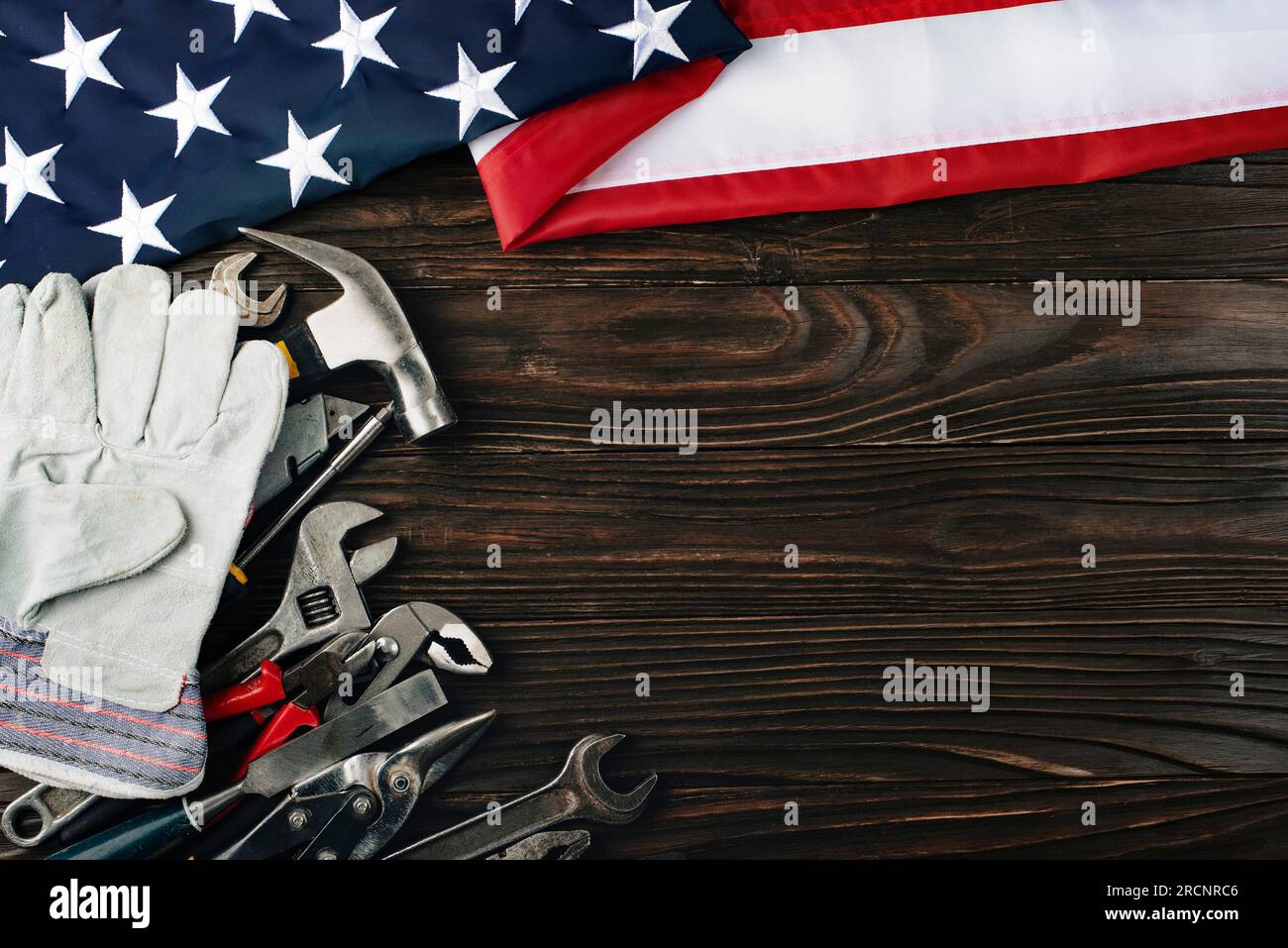 Attrezzi e noi bandiera su sfondo di legno banner del giorno di lavoro mockup Foto Stock