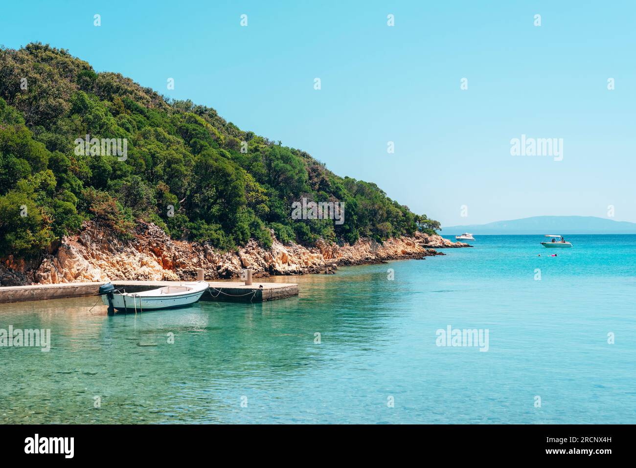 Barca nel mare blu sullo sfondo della costa. Concetto di viaggio per le vacanze estive. Foto Stock