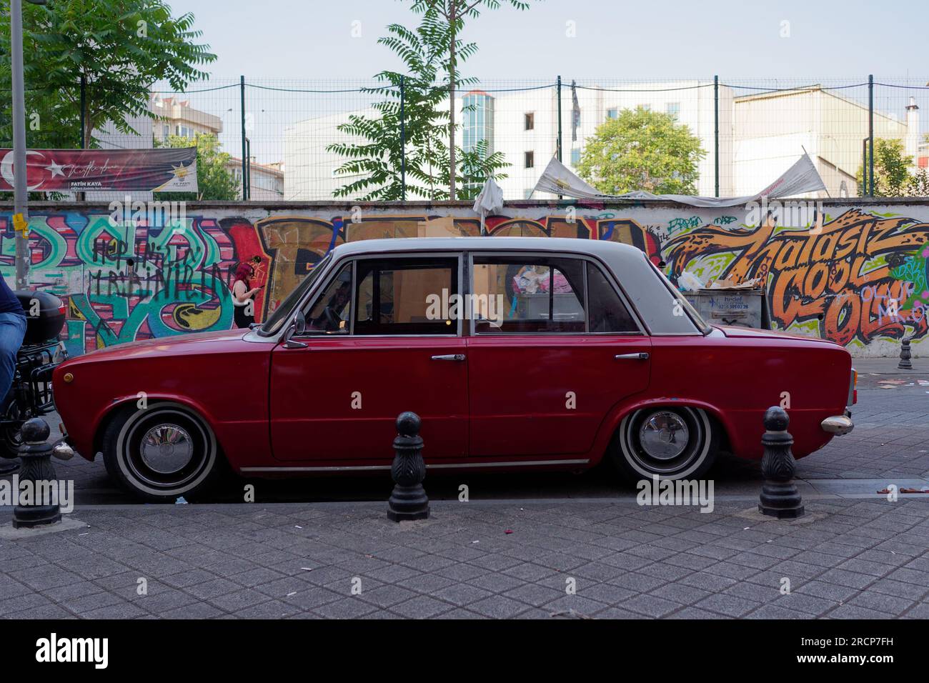 Auto rossa retrò con tetto bianco su una strada con graffiti nel quartiere Kadikoy sul lato asiatico di Istanbul, Turchia. Foto Stock