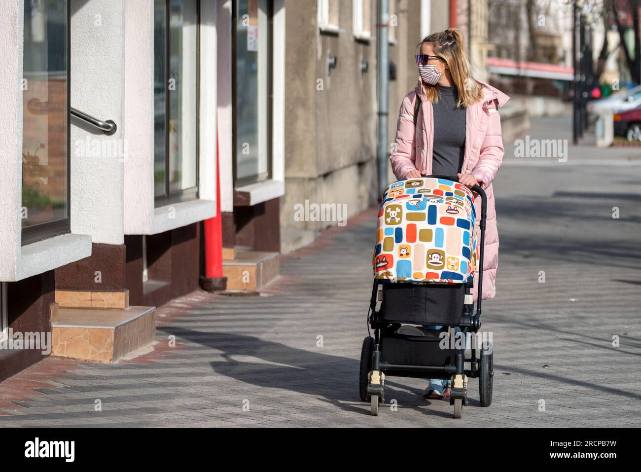 RUZOMBEROK, SLOVACCHIA - MARZO 26: Donna in maschera che spinge un passeggino nel cityon il 26 marzo 2020 a Ruzomberok Foto Stock