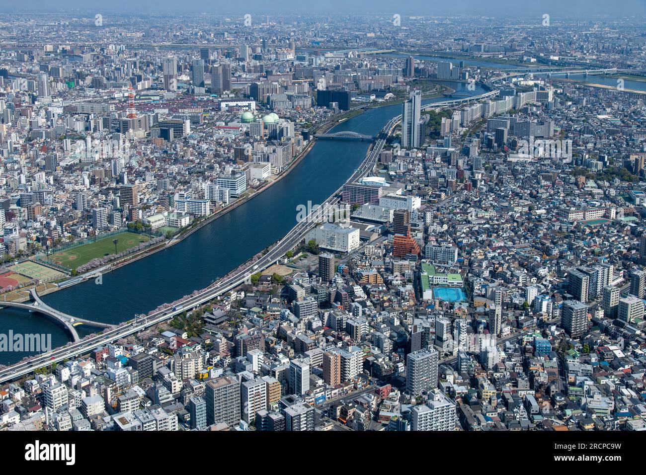 Vista aerea dei quartieri di Sumida e Taito City lungo il fiume Sumida a Tokyo, Giappone, con vista sulle aree residenziali e commerciali Foto Stock