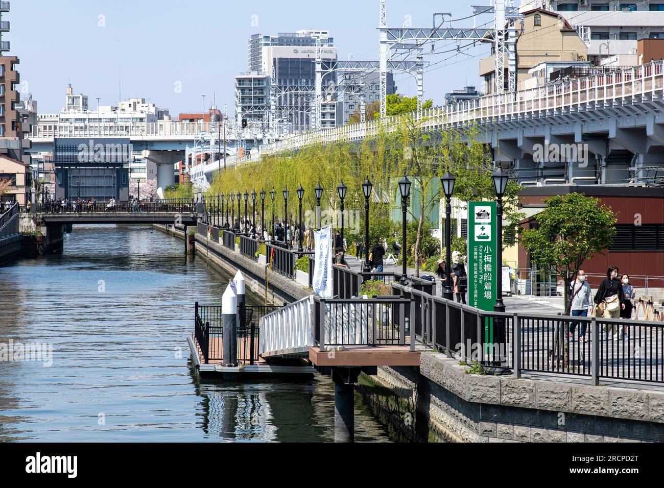 Tokyo, Giappone-aprile 2023; vista su un canale nel quartiere di Sumida dal ponte di Koume verso il ponte Genmori che conduce al fiume Sumida fiancheggiato da bar e. Foto Stock