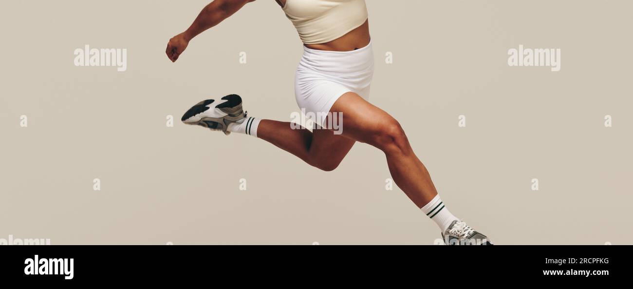 Giovane donna che corre in uno studio, che si occupa di allenamento della forza e di esercizi di movimento del corpo. Giovane donna atletica che si impegna per una b forte e muscolosa Foto Stock