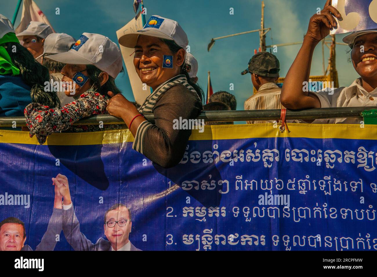 I sostenitori di Sam Rainsy cavalcano su un camion con uno striscione del CNRP durante una manifestazione politica prima delle elezioni nazionali. Phnom Penh, Cambogia. © Kraig Lieb Foto Stock