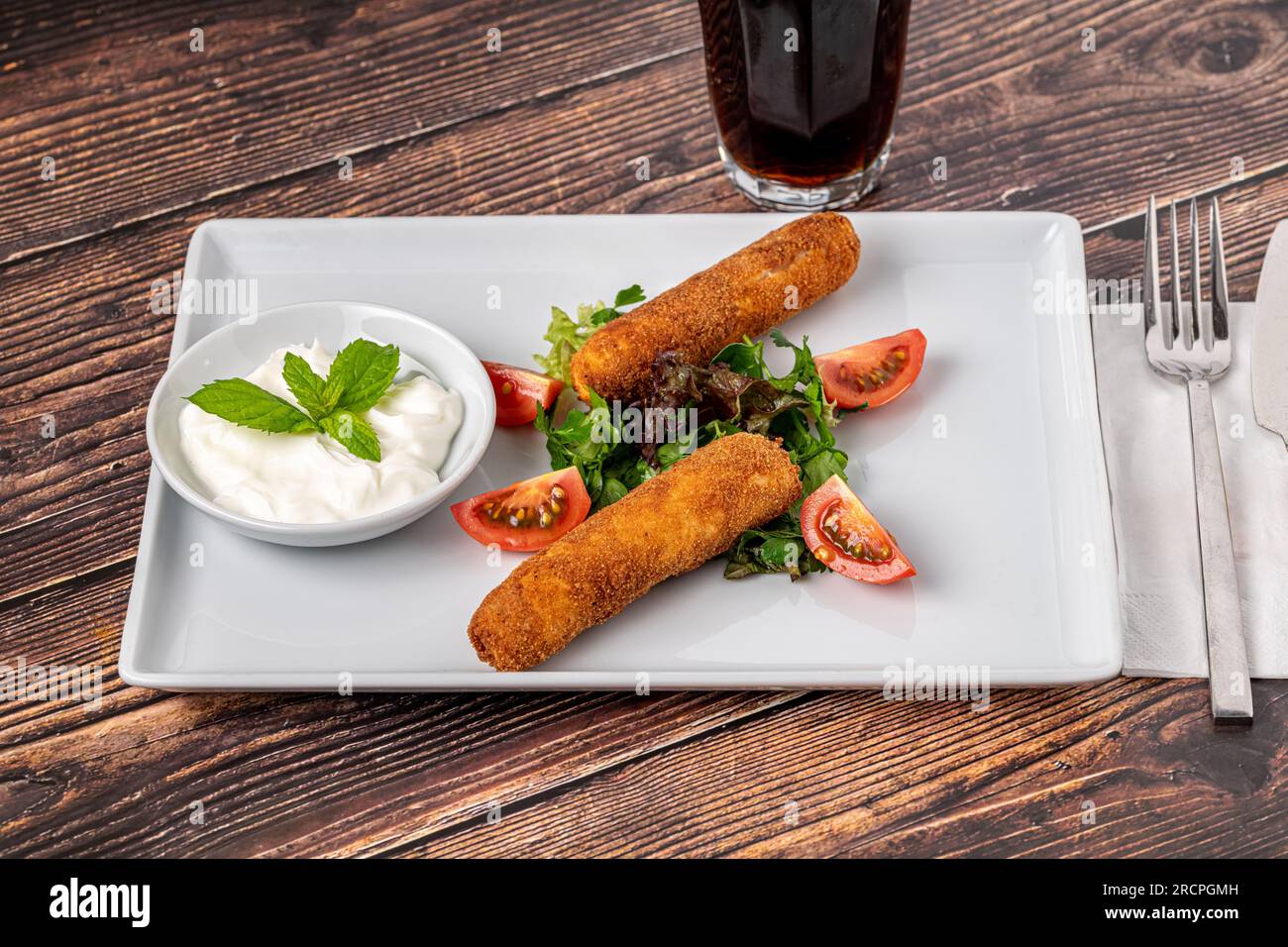 Bastoncini di mozzarella con verdure e salsa su un piatto di porcellana bianca Foto Stock