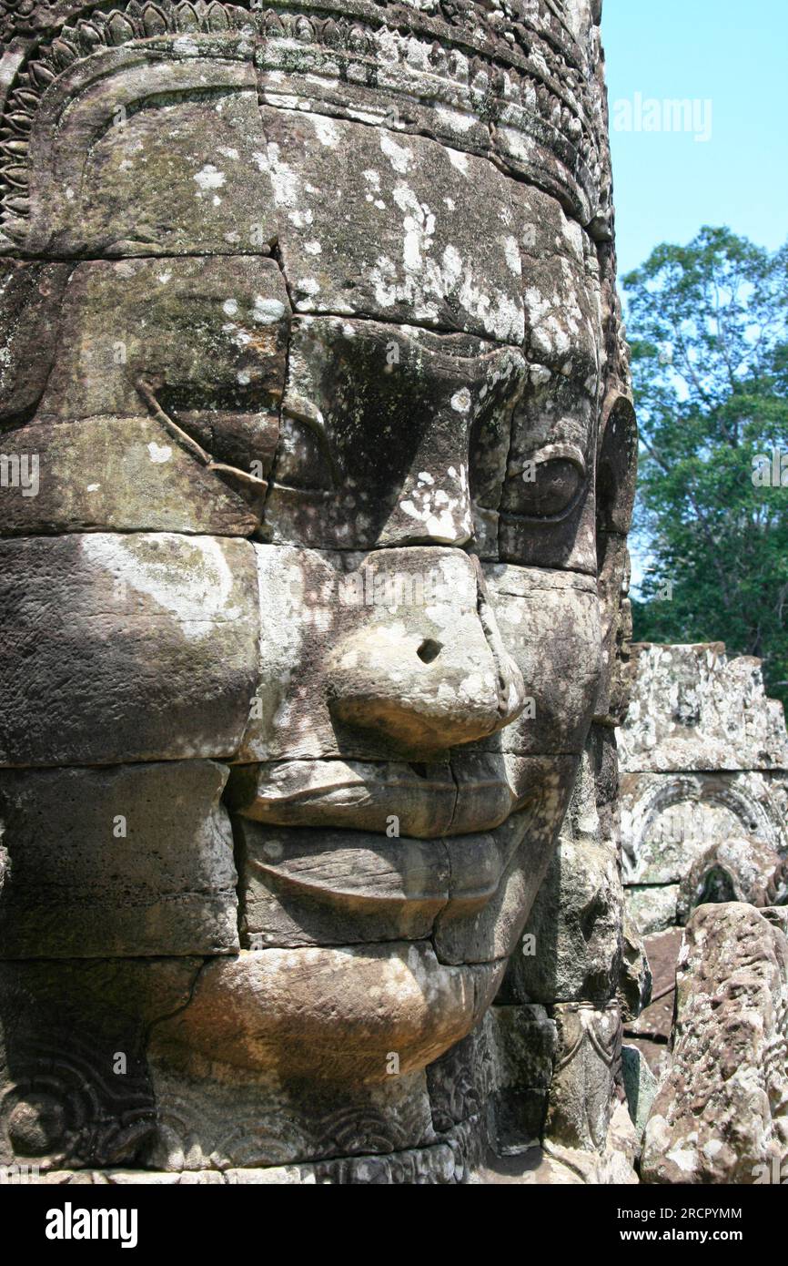 Dettagli di un volto Khmer scolpito in Angkor Thom. Foto Stock