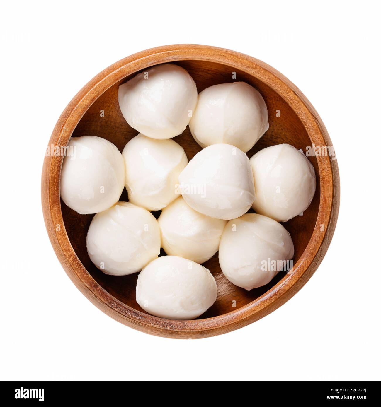 Mini palle di mozzarella, in una ciotola di legno. Formaggio bianco fresco dell'Italia meridionale a base di latte con il metodo della pasta filata, detto anche bambini bocconcini. Foto Stock