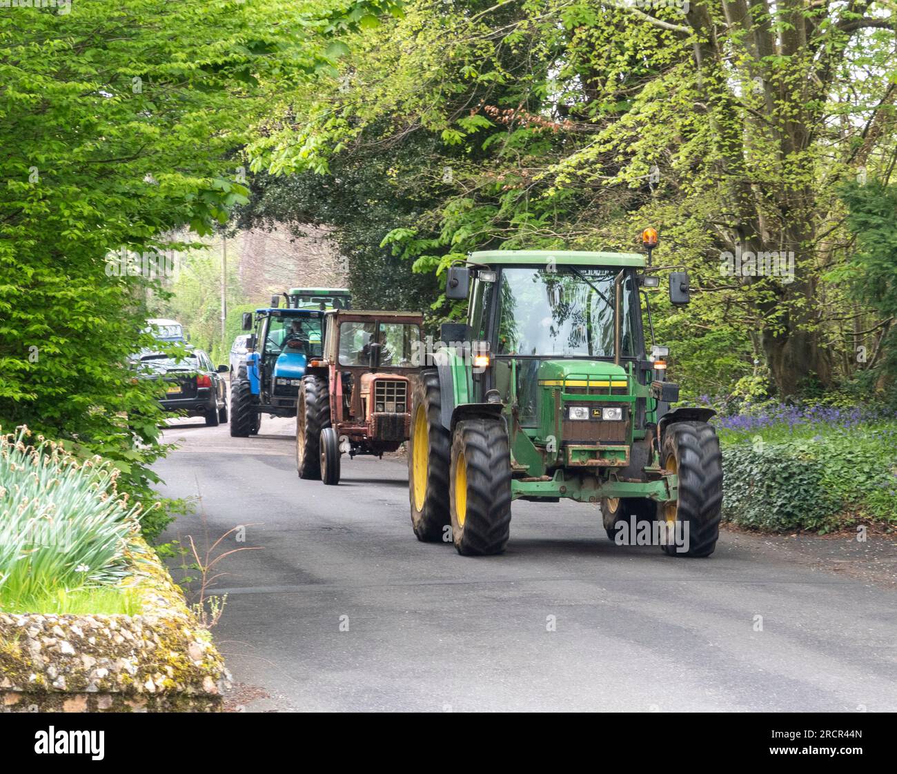 Una processione di trattori vecchi e nuovi attraverso Sidmouth, Devon. Foto Stock