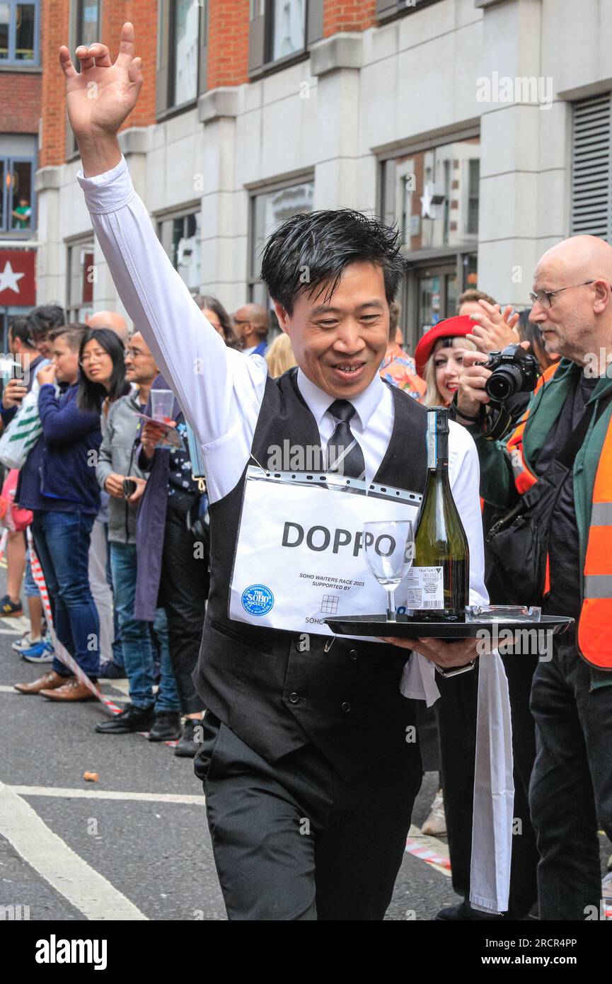 Londra, Regno Unito. 16 luglio 2023. I camerieri stanno arrivando al traguardo. L'annuale Soho Waiters Race si fa strada a Soho. La lunga tradizione, che risale al 1950, vede i camerieri di molti ristoranti e bar nelle vicinanze correre per le strade di Soho con un vassoio, un tovagliolo, una mezza bottiglia di champagne e un bicchiere di champagne. I camerieri poi festeggiano dopo. Crediti: Imageplotter/Alamy Live News Foto Stock