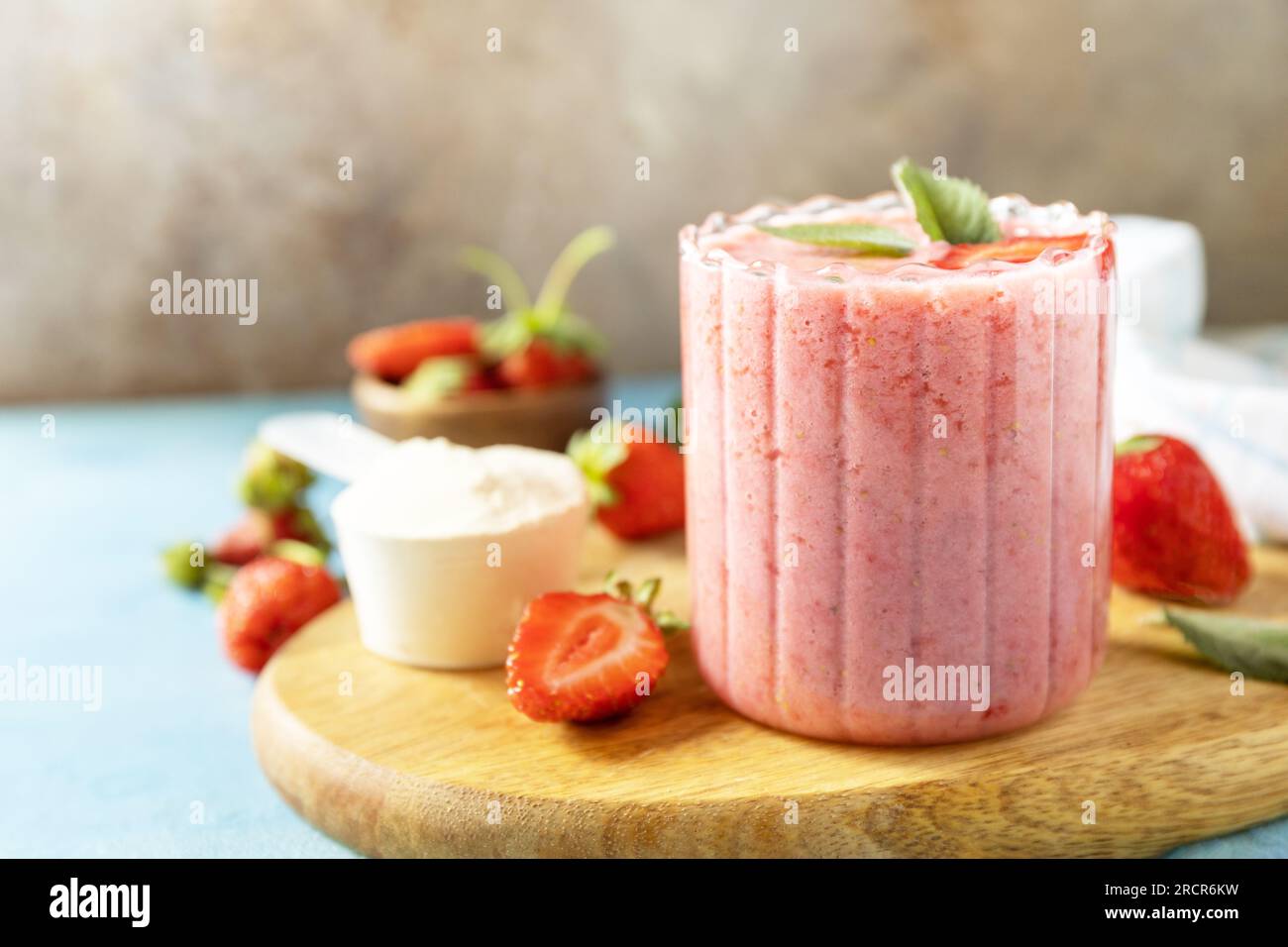 Latte fresco, bevande alla fragola su tavola di legno su uno sfondo di pietra, frullato proteico con frutti di bosco freschi. Copia spazio. Foto Stock