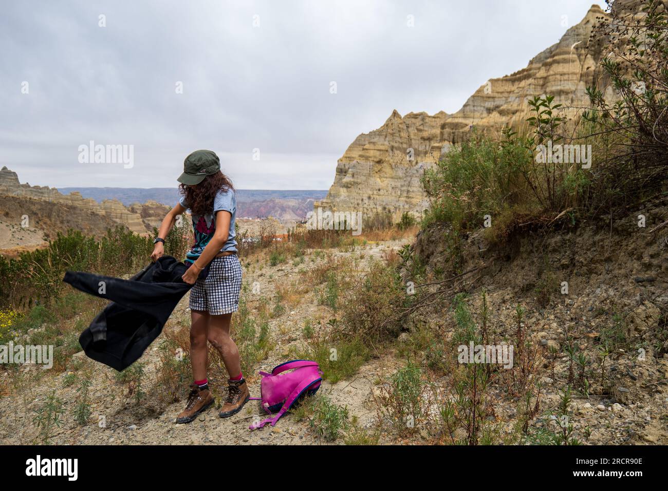 Palca, la Paz, Bolivia - 7 agosto 2022: La giovane donna indigena scuote il suo giubbotto durante una passeggiata nelle montagne della Valle de Las Animas (Valle degli spiriti) Foto Stock