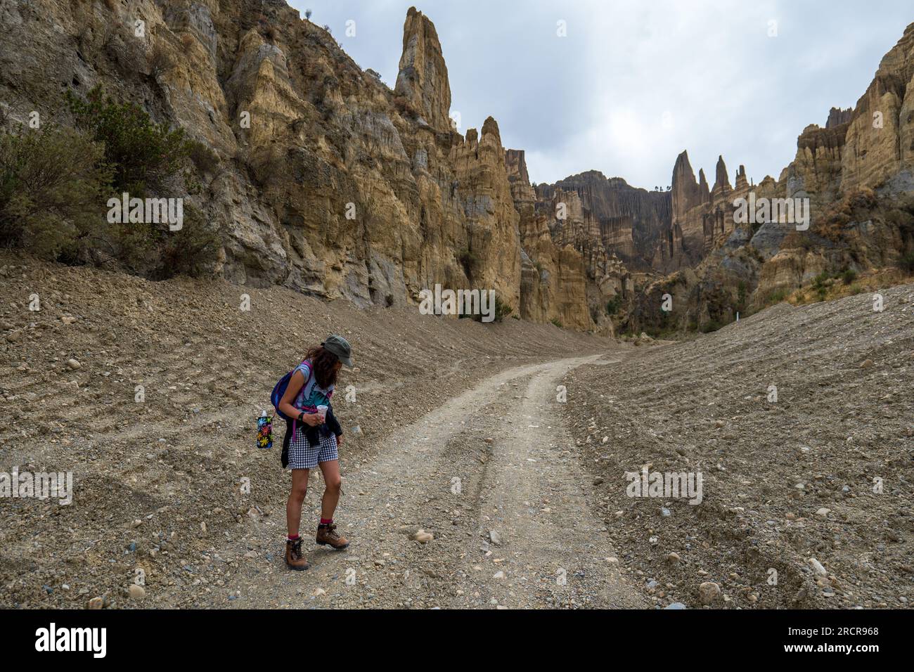 Palca, la Paz, Bolivia - 7 agosto 2022: La giovane donna indigena guarda verso il basso le rocce durante una passeggiata nelle montagne della Valle de Las Animas (Spirit Foto Stock