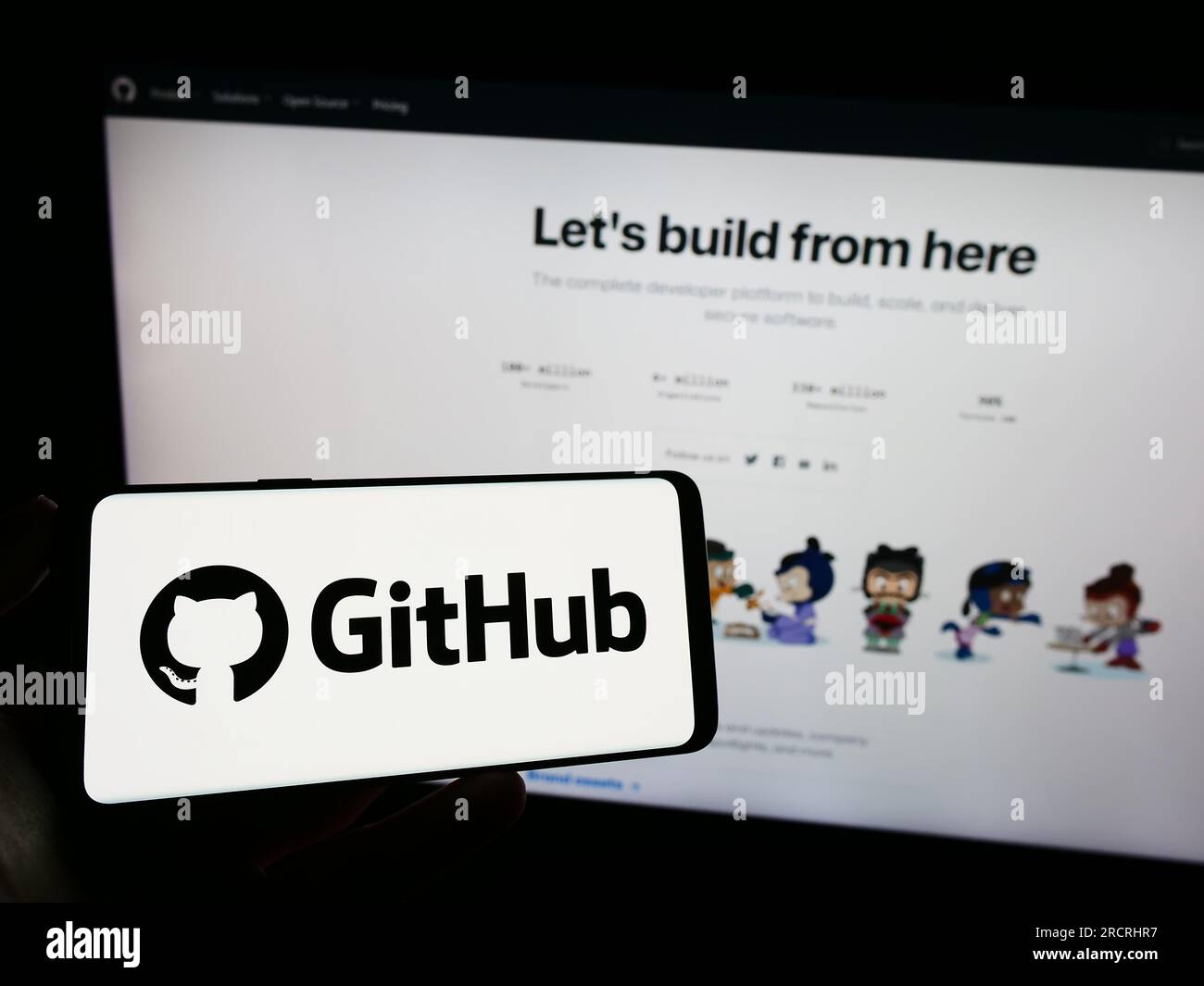 Persona che possiede un telefono cellulare con il logo della società statunitense di sviluppo software GitHub Inc. Sullo schermo davanti alla pagina Web. Concentrarsi sul display del telefono. Foto Stock