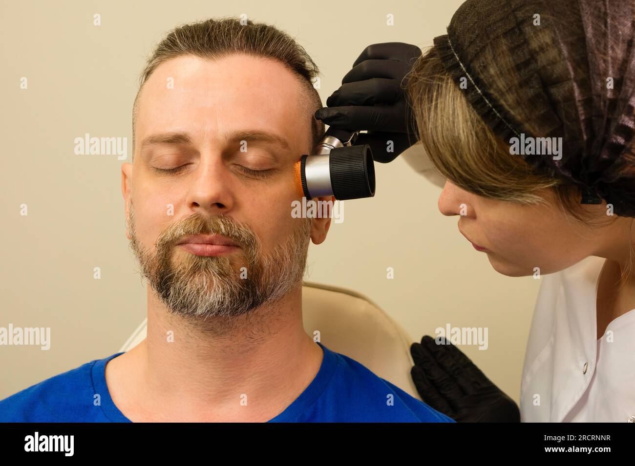 Il dermatologo esamina il segno di nascita del paziente con il dermatoscopio. Controllo talpa. Dermoscopia Foto Stock