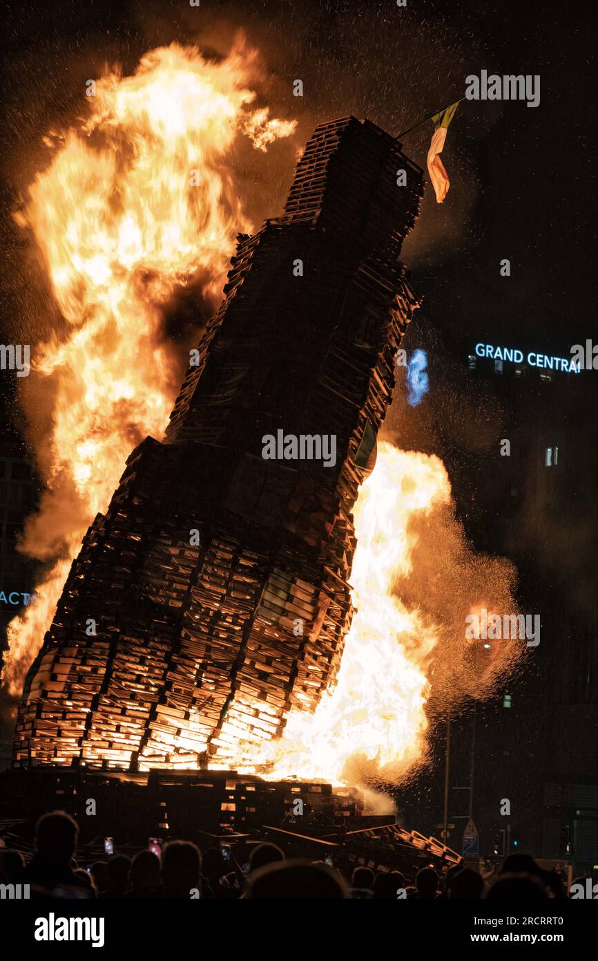 11 luglio 2023, Belfast, Irlanda: Il falò a Sandy Row inizia a cadere dopo meno di tre minuti di incendio. Le pire, costruite con pallet di legno e talvolta pneumatici e altri materiali, sono costruite in tutta l'Irlanda del Nord nei quartieri protestanti per l'annuale 11 luglio, o celebrazioni dell'undicesima notte per commemorare la conquista guglielamita degli anni '1690, che ha dato inizio all'ascendenza protestante in Irlanda. Le pire sono generalmente adornate con il tricolore irlandese e altre regalia o simboli associati al nazionalismo irlandese e all'identità come provocazione verso il commun cattolico Foto Stock