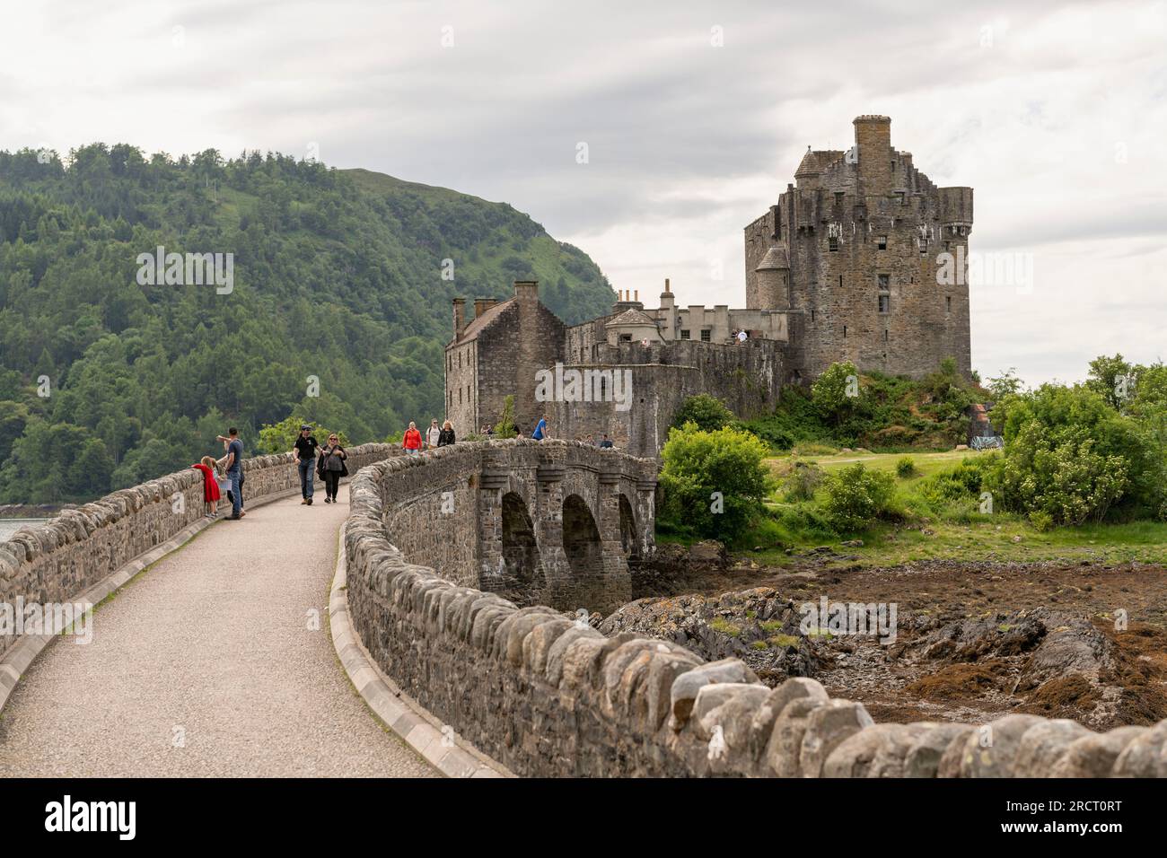 I visitatori della passerella sul ponte all'ingresso del castello di Eilean Donan nelle Highlands scozzesi Foto Stock