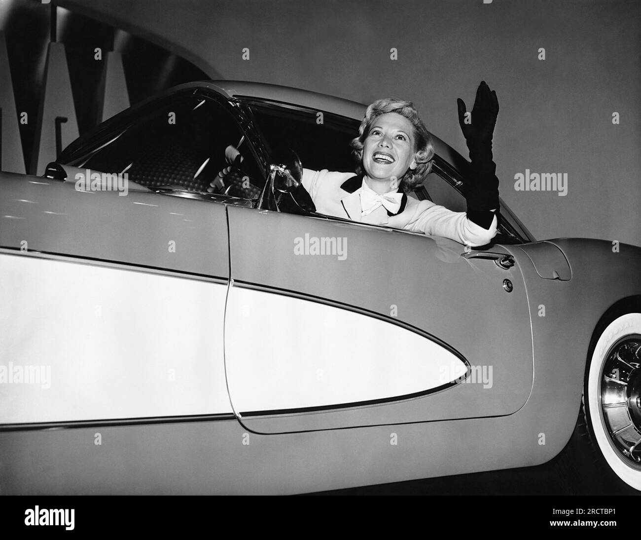 New York, New York: Gennaio 1956 Dinah Shore salta dal sedile del pilota di una Corvette del 1956 al General Motors Motorama Show. Chevrolet era la sponser del suo programma televisivo. Foto Stock