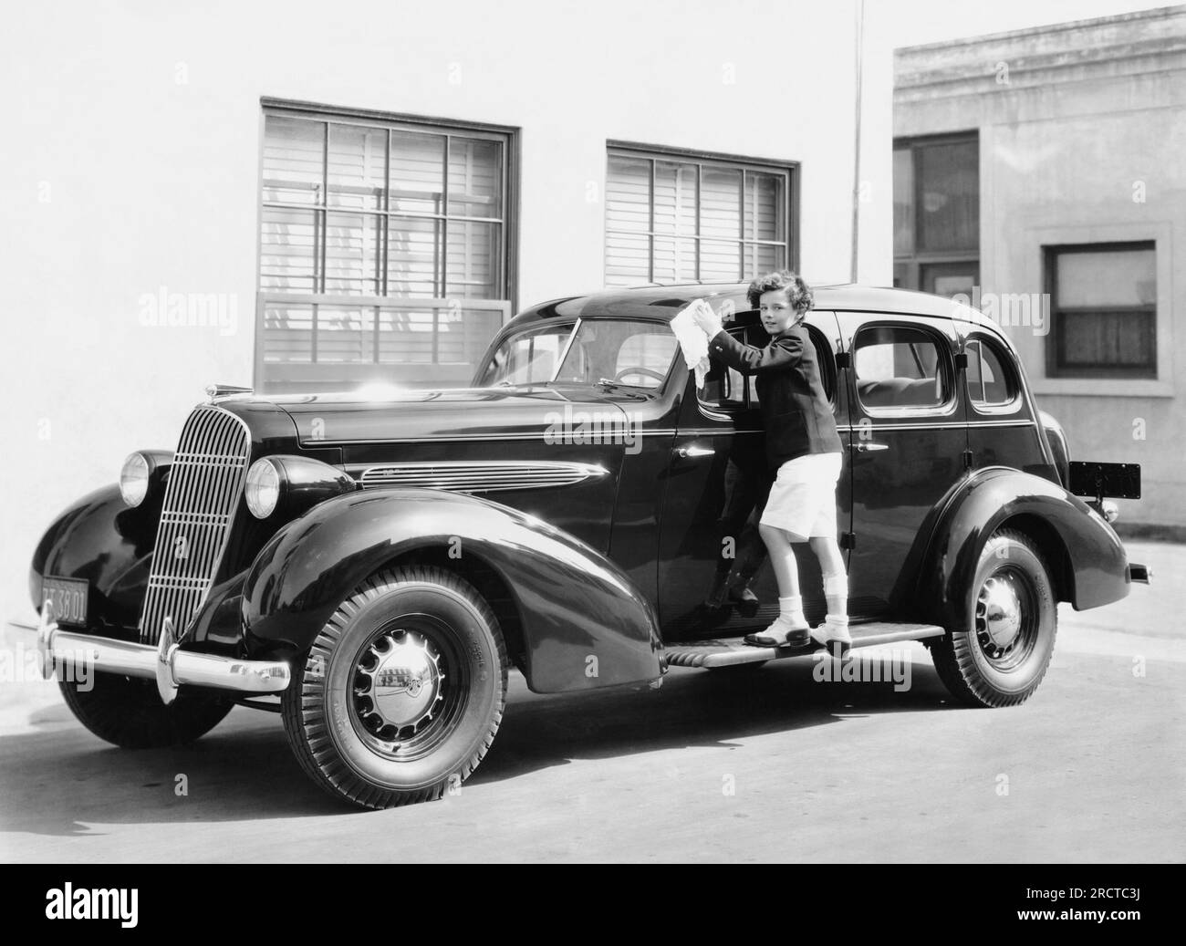 Hollywood, California: c. 1938 Un ragazzo che pulisce un'automobile. Foto Stock