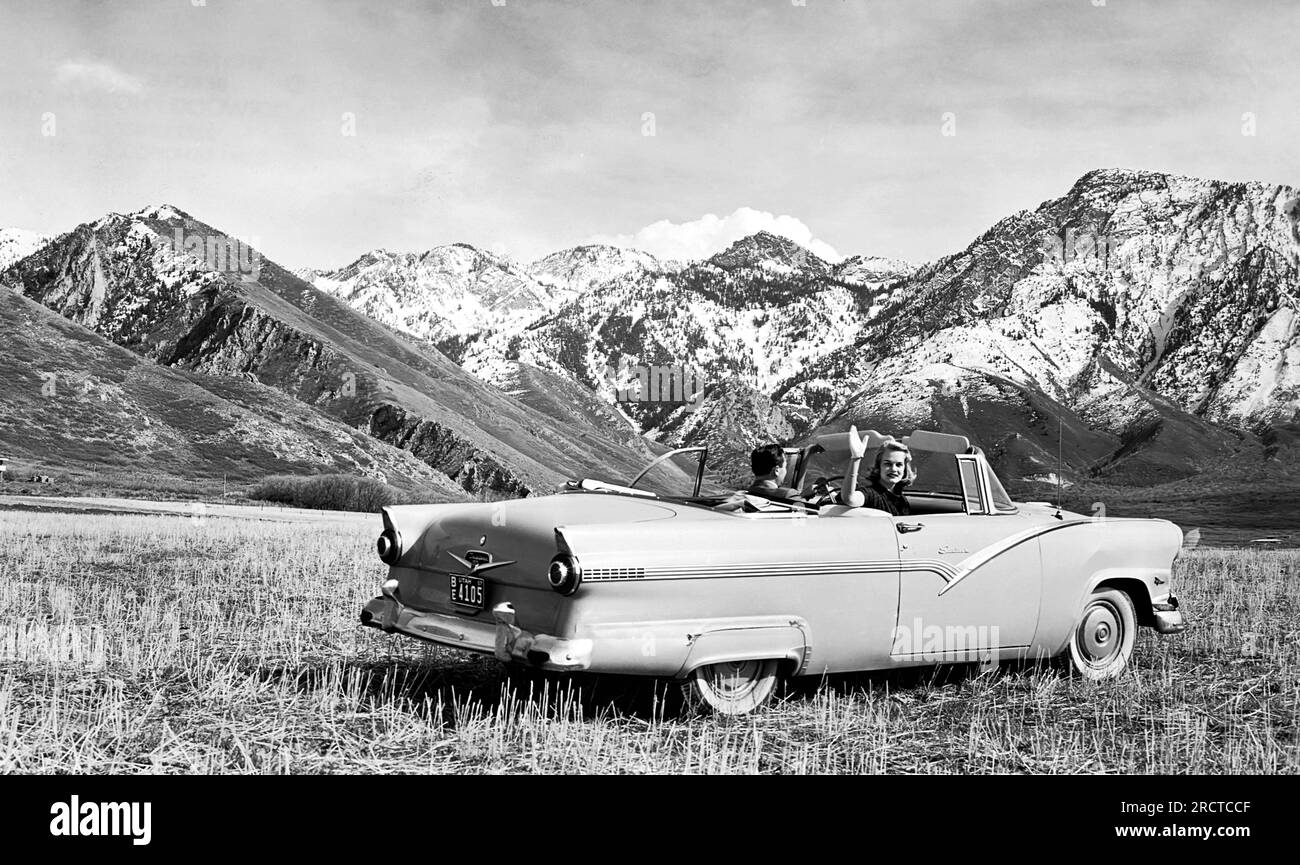 Utah: 1957 Una coppia parcheggiata in un prato di montagna con la Ford convertibile del 1956. Foto Stock