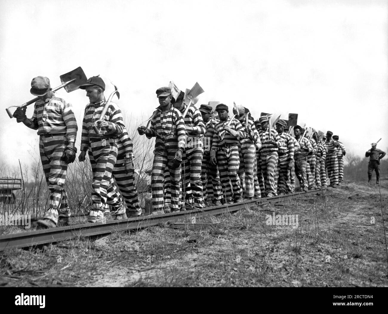 Macon, Georgia, 8 marzo 1937 Una gang della catena della contea di Bibb con picchetti e pale torna dal lavoro per tutta la giornata. La contea ha recentemente istituito un giorno di otto ore per i detenuti. Foto Stock