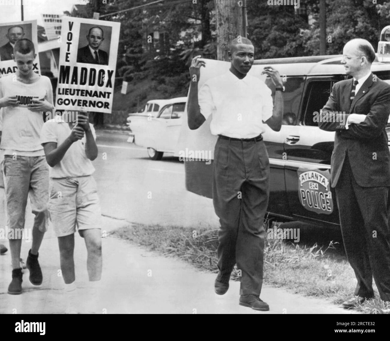 Atlanta, Georgia: 3 luglio 1962, il candidato segregazionista e vice governatore Lester Maddox guarda come delegato ai picchetti della convenzione NAACP davanti al suo ristorante e diversi ragazzi portano i cartelli per la sua candidatura. Foto Stock