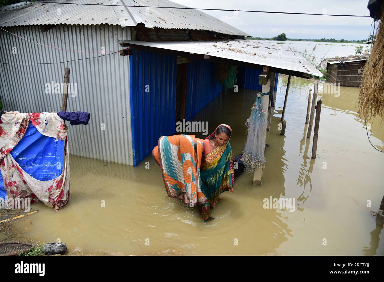 Morigaon. 16 luglio 2023. Una donna sposta i suoi effetti personali fuori dal suo baraccopoli in un'area colpita dalle inondazioni nel distretto di Morigaon, nello stato nordorientale dell'Assam, in India, il 16 luglio 2023. Crediti: Str/Xinhua/Alamy Live News Foto Stock