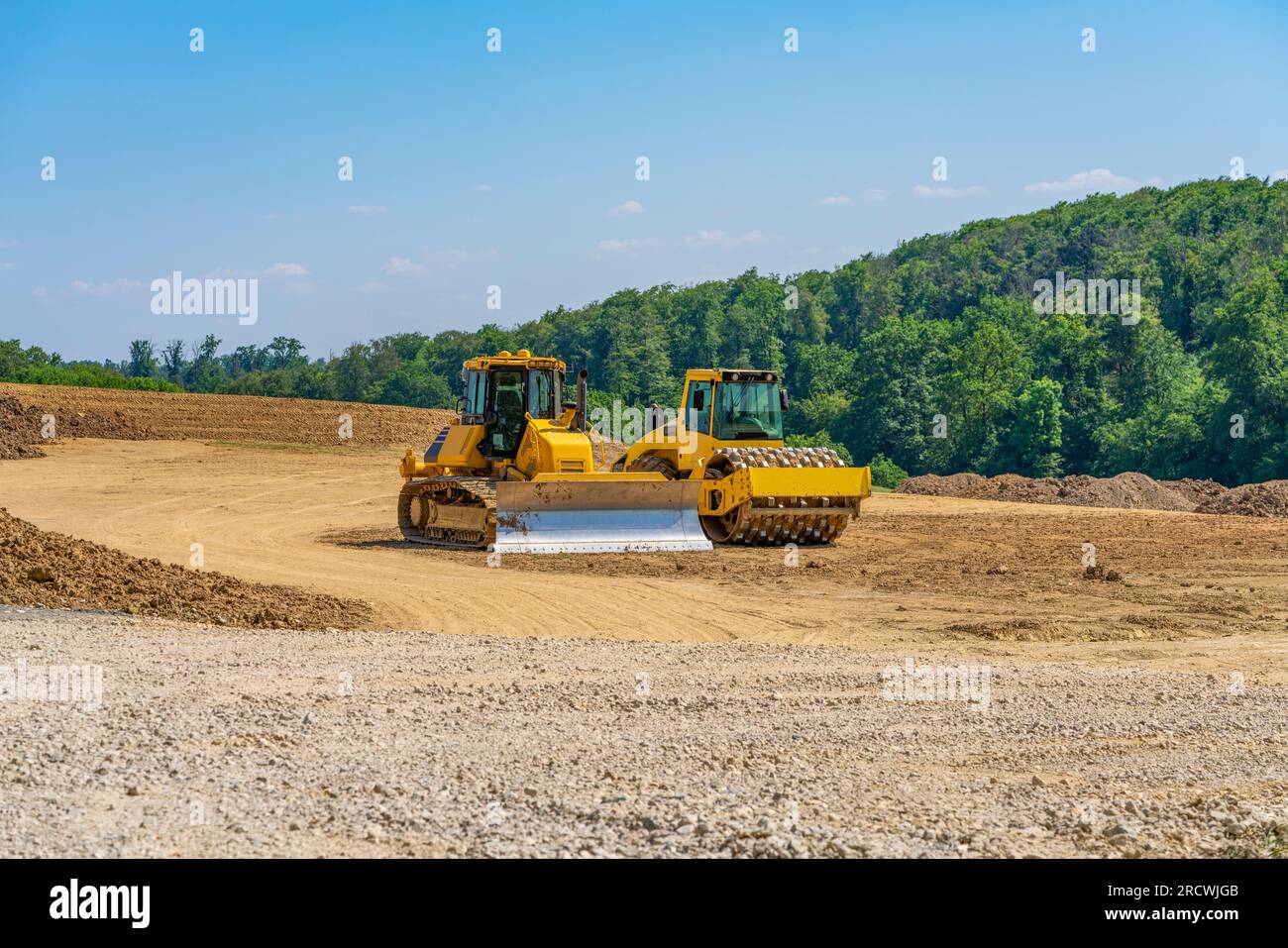 Apripista e compattatore a rulli affiancati su un lotto di costruzione, Foto Stock