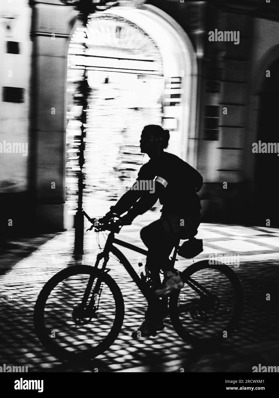 silhouette della donna che va in bicicletta di notte Foto Stock
