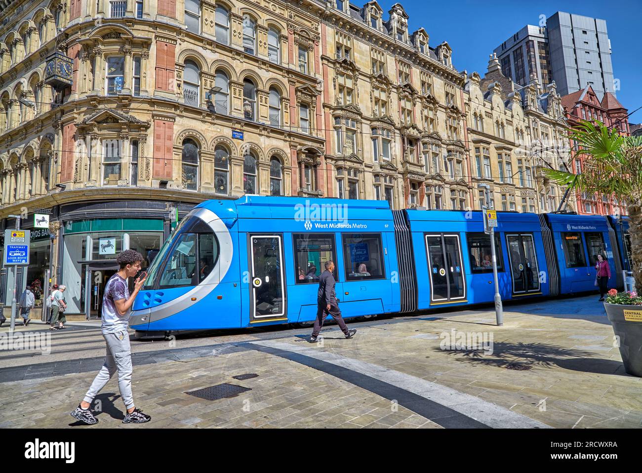 Tram di Birmingham contro le facciate degli edifici fronting Corporation Street Birmingham, Inghilterra, Regno Unito Foto Stock