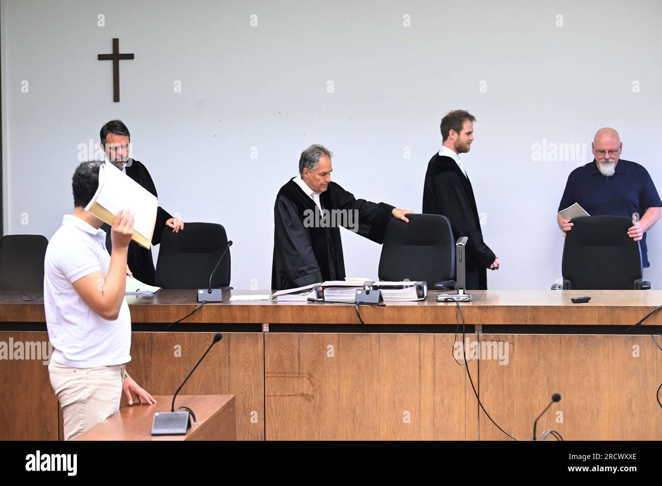 Monaco, Germania. 17 luglio 2023. L'imputato (l) si trova in aula presso il tribunale regionale di Monaco i durante l'apertura del processo per omicidio in una clinica psichiatrica, mentre il giudice Norbert Riedmann (3° da destra) entra nella stanza. Si dice che un uomo malato di mente abbia torturato e ucciso un altro paziente con una barra di ferro. Credito: Felix Hörhager/dpa - ATTENZIONE: Le persone sono state pixelate per motivi legali/dpa/Alamy Live News Foto Stock