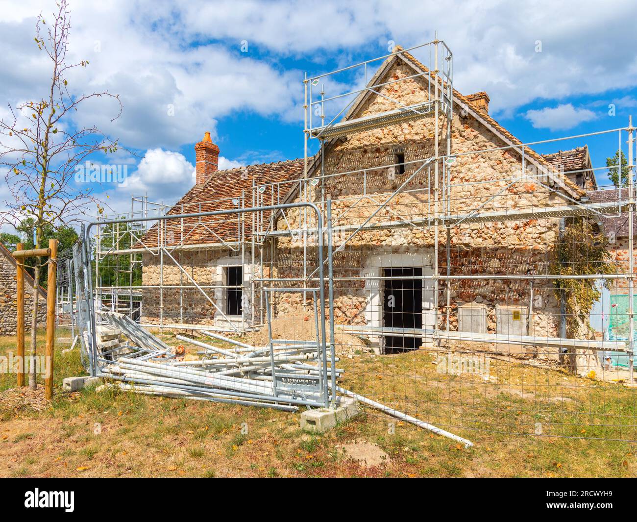 Impalcature che circondano la vecchia casa di campagna in fase di ristrutturazione - Rosnay, Indre (36), Francia. Foto Stock