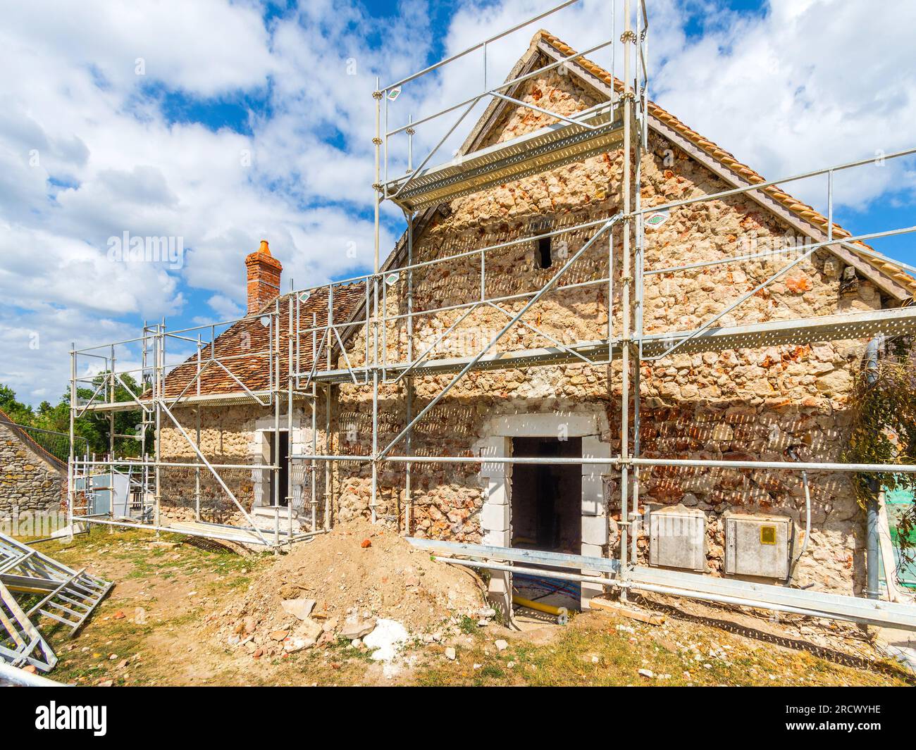Impalcature che circondano la vecchia casa di campagna in fase di ristrutturazione - Rosnay, Indre (36), Francia. Foto Stock