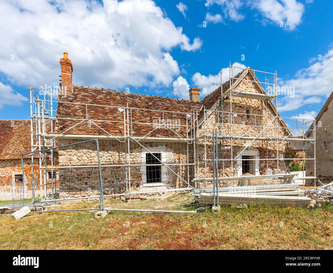 Impalcature che circondano la vecchia casa di campagna in fase di ristrutturazione - Rosnay, Indre (36), Francia. Foto Stock