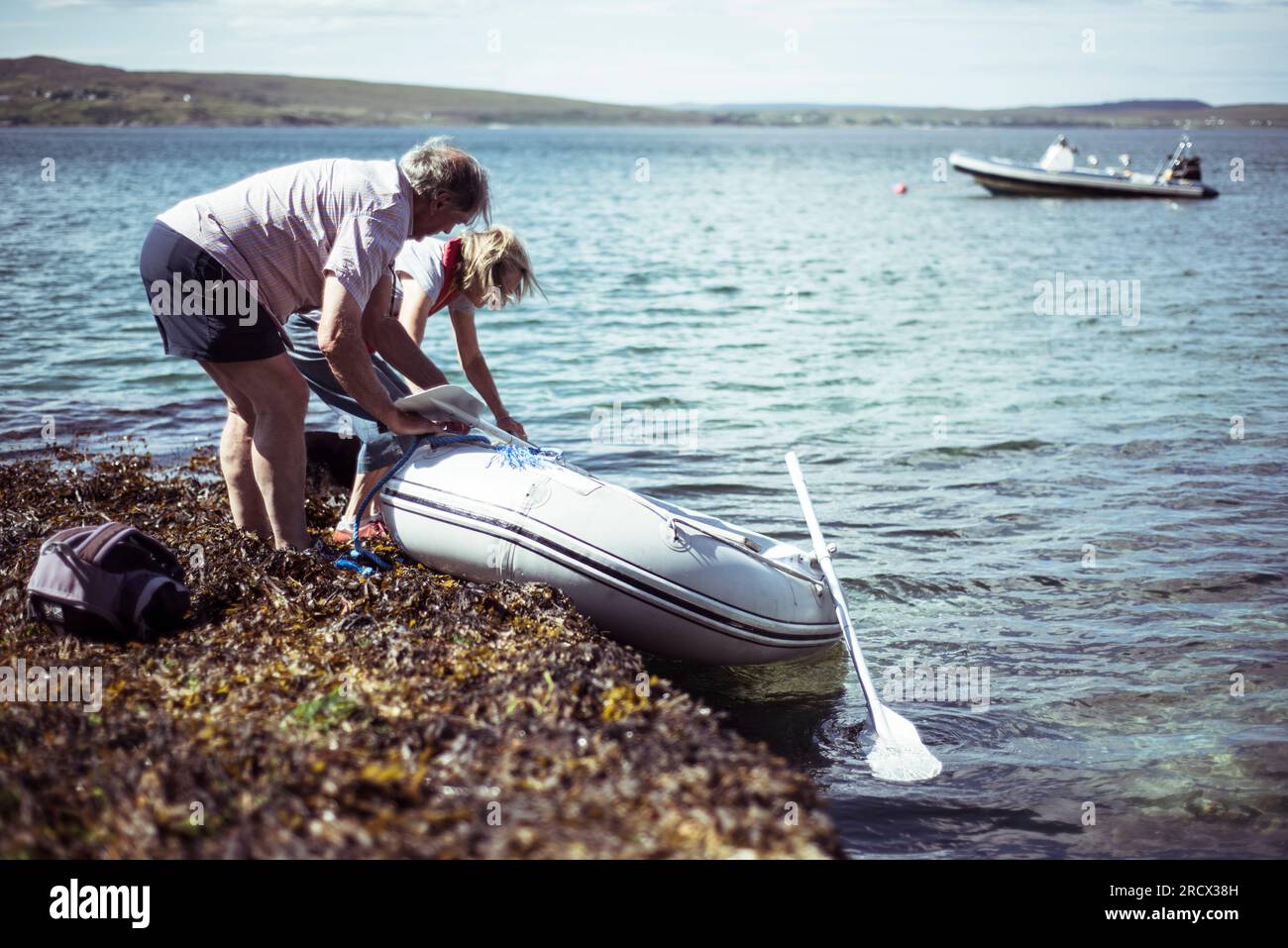 La coppia in pensione porta la barca in acqua Foto Stock
