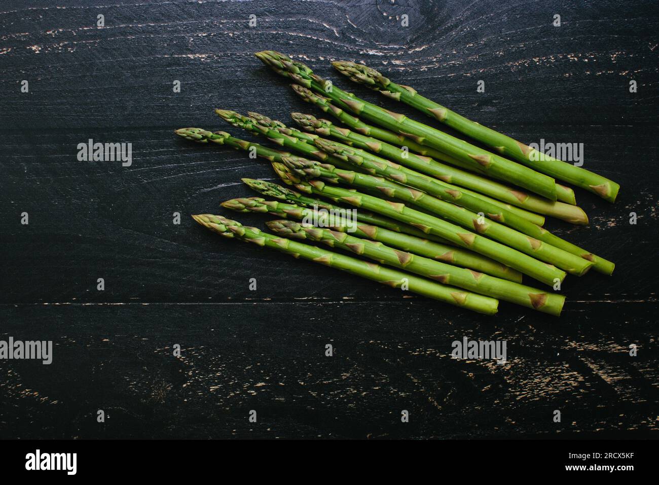 Mazzo di asparagi freschi raccolti su un tavolo di legno rustico scuro Foto Stock