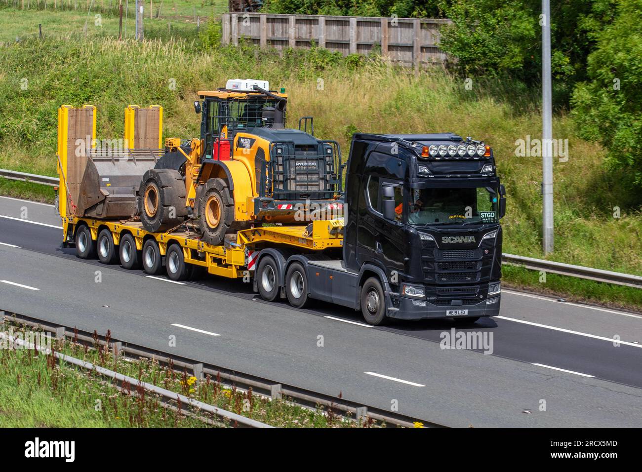 Dumper 2019 "Argyll Style" Scania Diesel da 16353 cc, con pala ribassata articolata STGO CAT 2 che trasporta pale gommate HYUNDAI HL960, in viaggio sull'autostrada M6 a Greater Manchester, Regno Unito Foto Stock