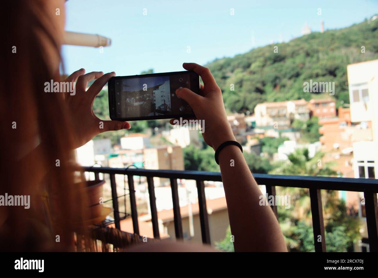 Donna che scatta una foto in montagna con il suo cellulare. Foto Stock