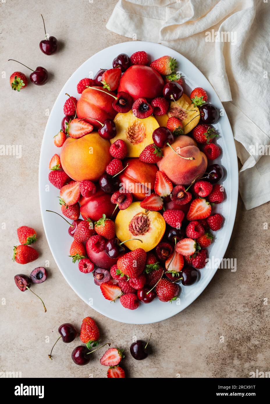 Vista dall'alto di un grande vassoio di frutta mista: Frutti di bosco, pesche, ciliegie. Foto Stock