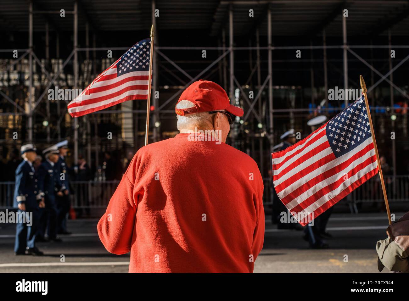 L'anziano batte la bandiera americana alla sfilata del Veteran's Day di New York Foto Stock