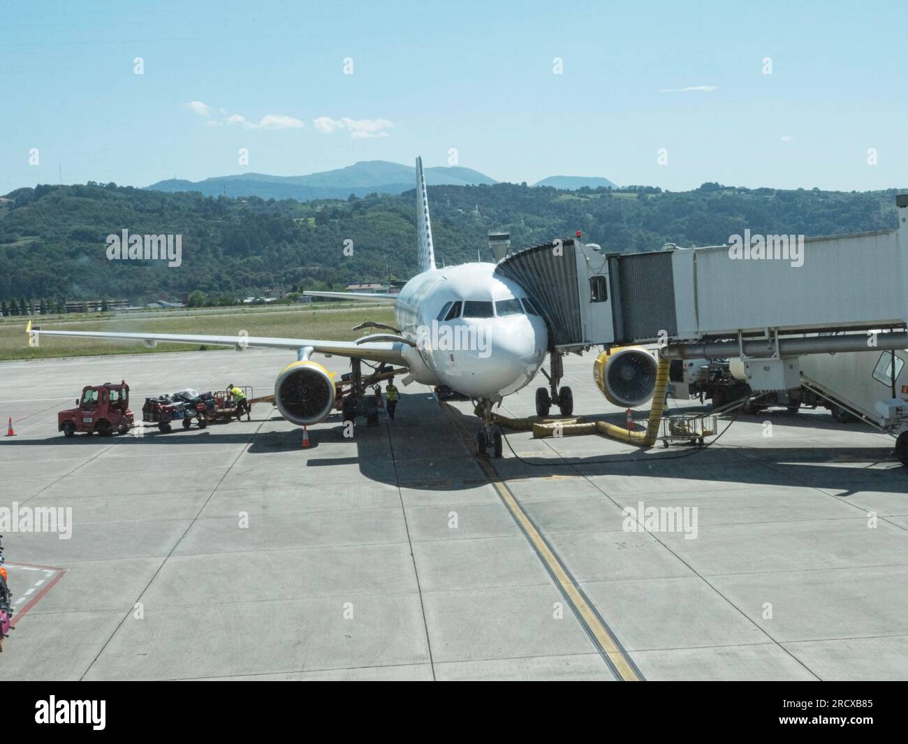 Aereo all'aeroporto con ponte passeggeri collegato al terminal dell'aeroporto tramite ponte jet. Bilbao, Spagna - 14 luglio. 2023. Foto Stock