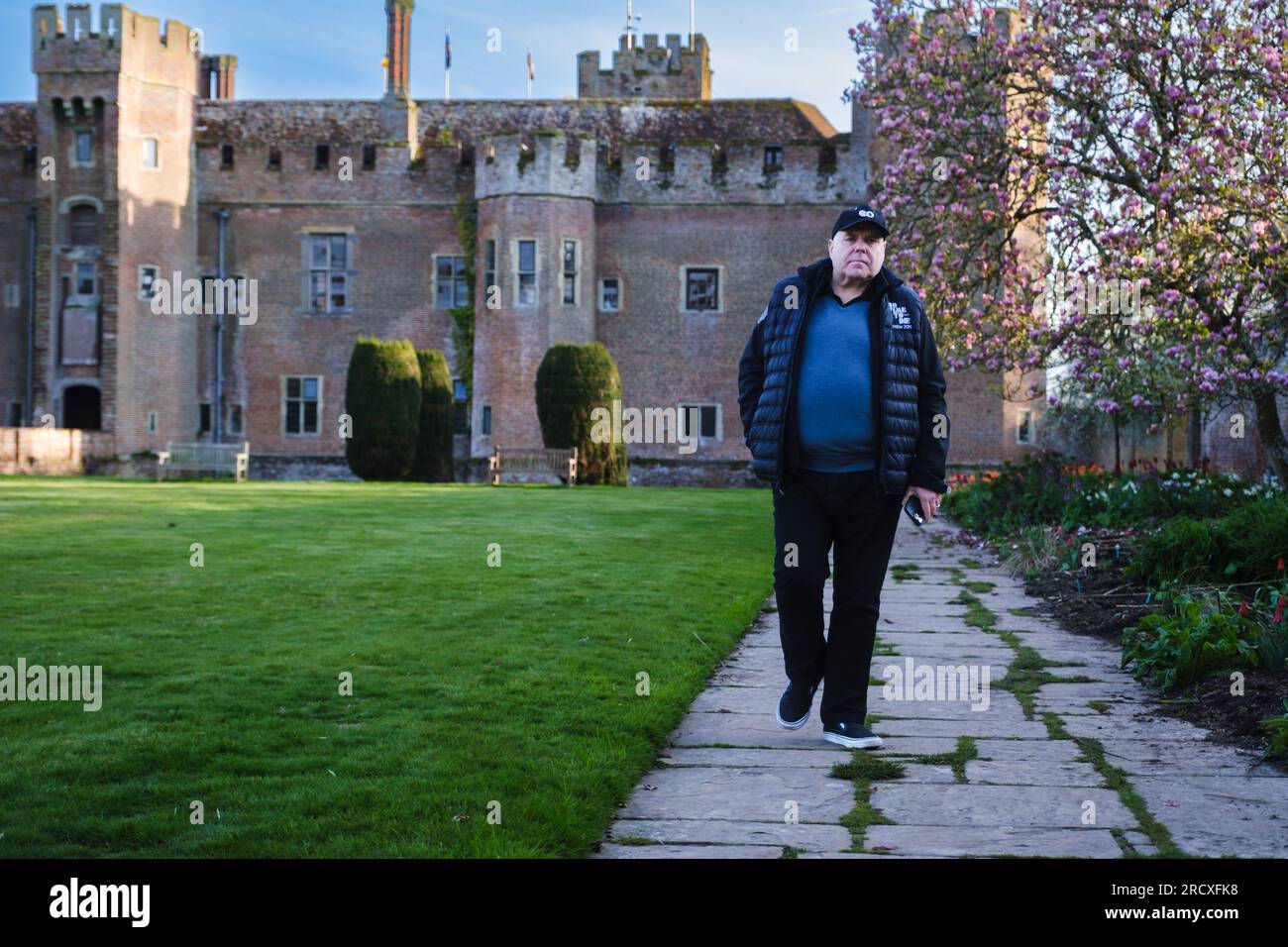 Un visitatore solitario cammina attraverso i giardini murati fotografati al castello di Herstmonceux nell'East Sussex, Regno Unito, il 16 aprile 2023. Foto di Julie Edwards. Foto Stock